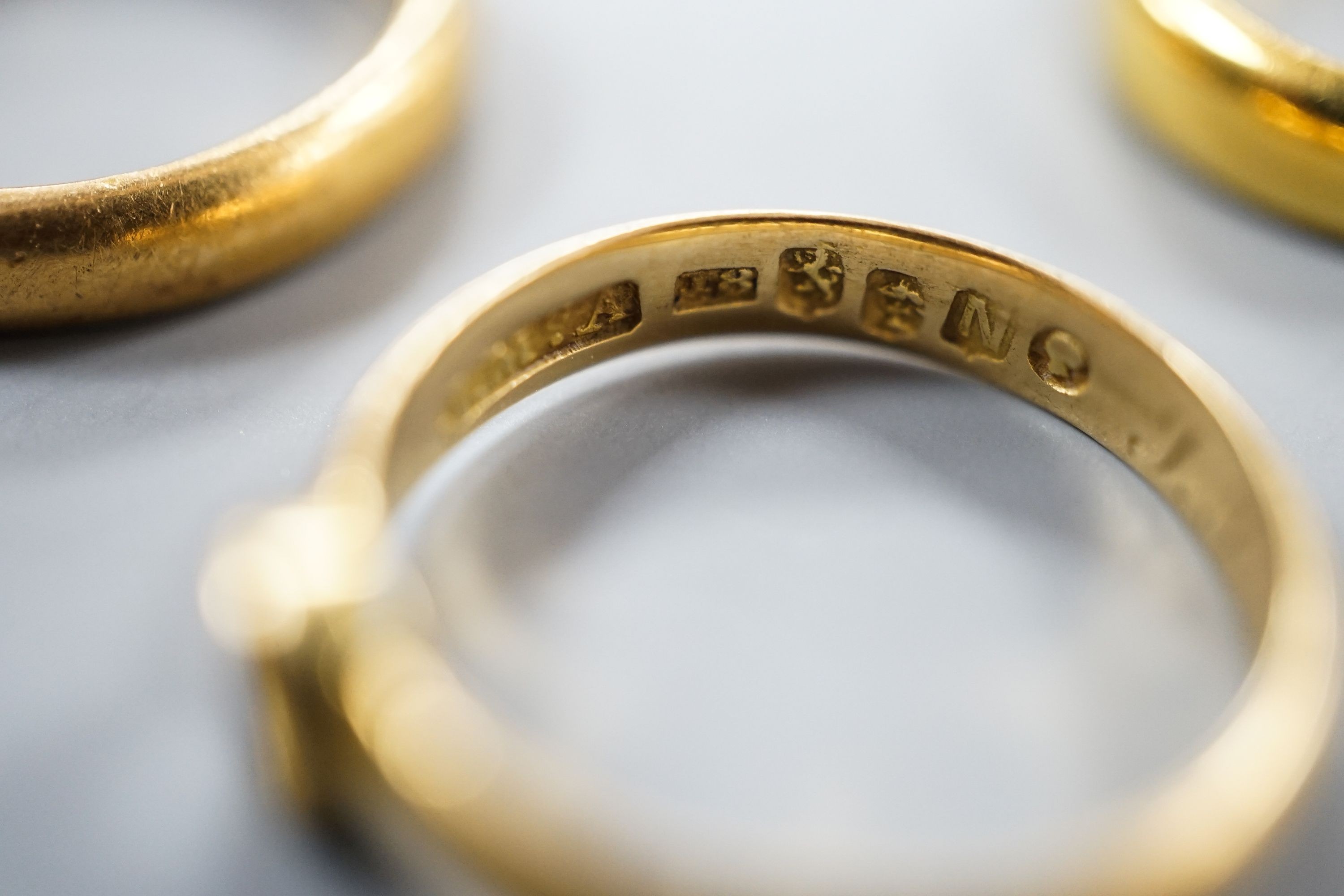 Two 22ct gold wedding bands, 10.3 grams, a George V 18ct gold wedding band and a Victorian 18ct gold shank, 6.6 grams.